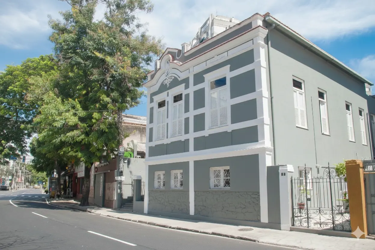 Fachada do Gaia Hostel em Botafogo em um casarão histórico cinza e branco.