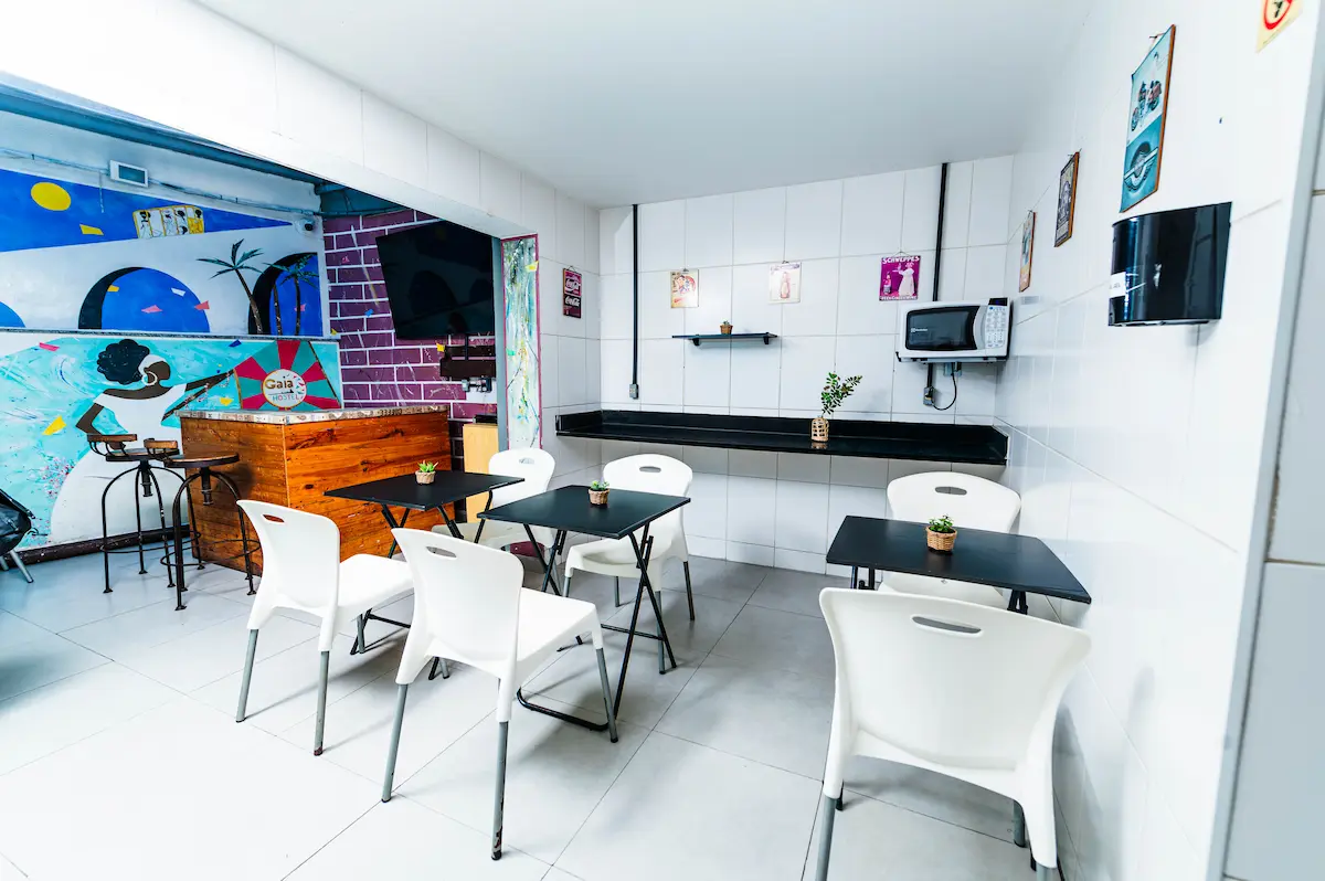 Área de café da manhã em hostel em Botafogo com mesas e ambiente organizado.