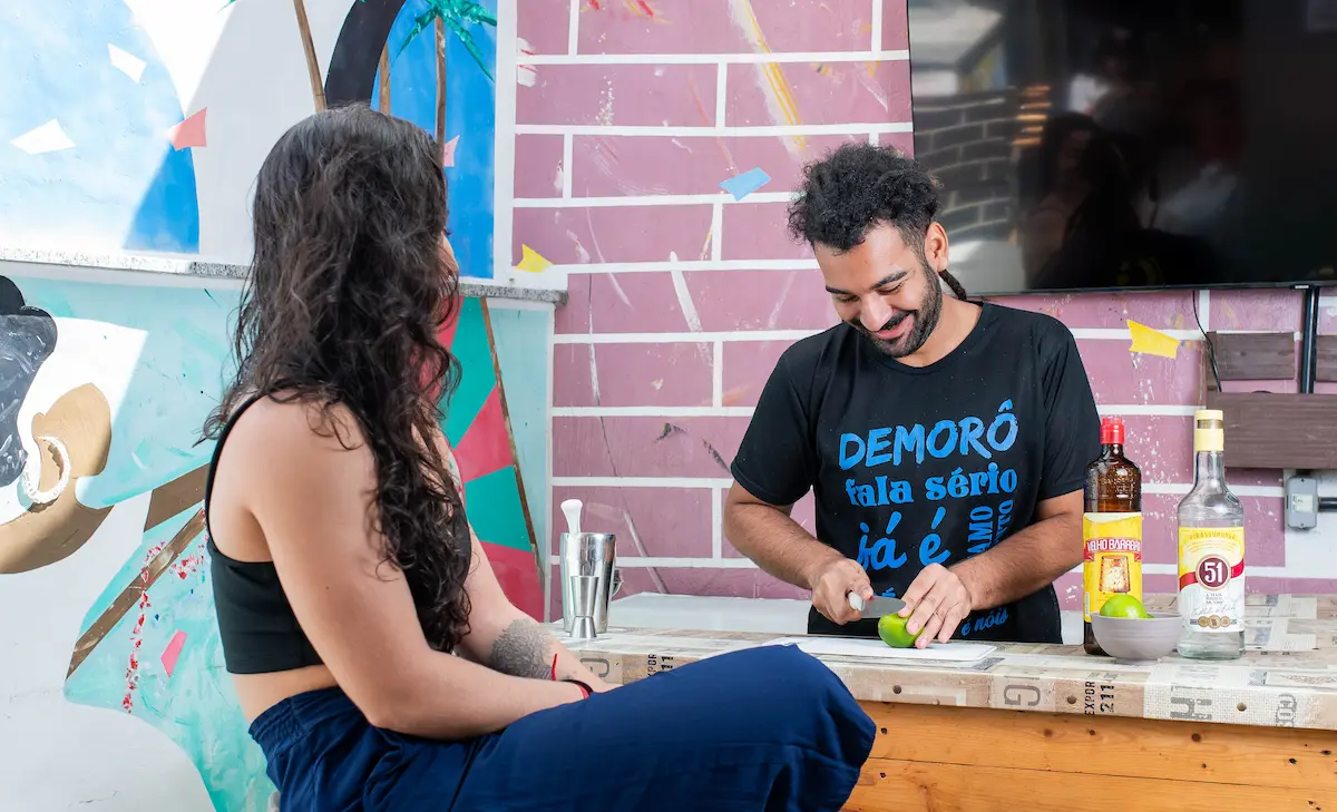 Barman preparando drink em hostel no Rio de Janeiro.